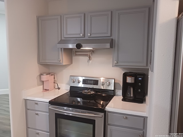 kitchen featuring gray cabinets, hardwood / wood-style flooring, and stainless steel range with electric stovetop