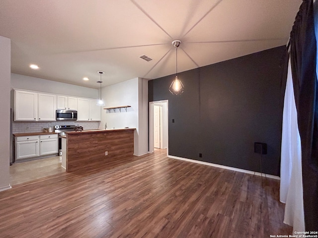 kitchen featuring decorative light fixtures, hardwood / wood-style floors, and white cabinetry