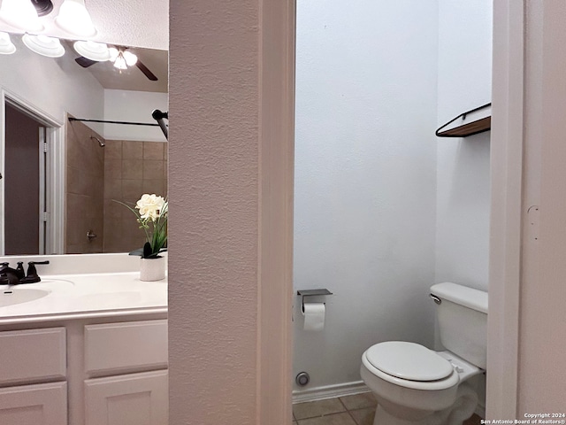 bathroom with tiled shower, vanity, toilet, and tile patterned floors