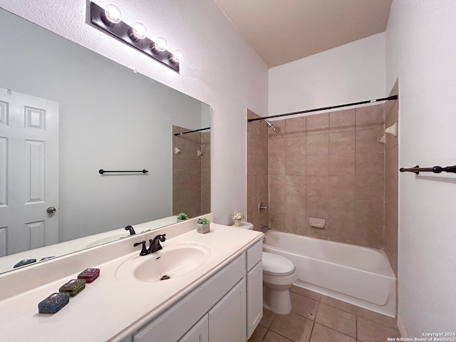 full bathroom with tile patterned flooring, toilet, tiled shower / bath combo, and vanity