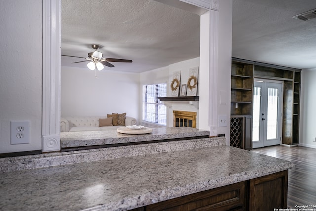 kitchen with dark wood-type flooring, a textured ceiling, plenty of natural light, and ceiling fan