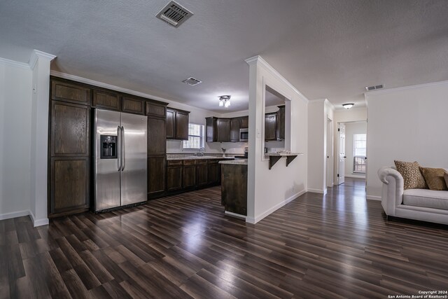 kitchen featuring dark wood-type flooring, plenty of natural light, stainless steel appliances, and dark brown cabinets