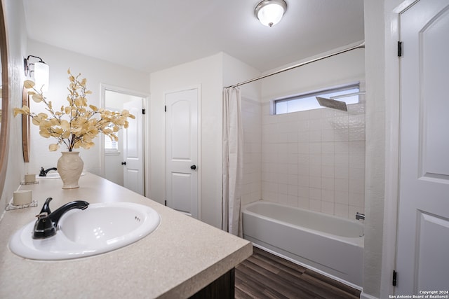 bathroom with hardwood / wood-style flooring, shower / tub combo, and vanity