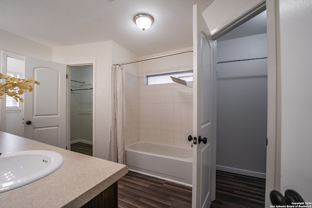 bathroom featuring hardwood / wood-style floors, vanity, shower / tub combo, and a healthy amount of sunlight