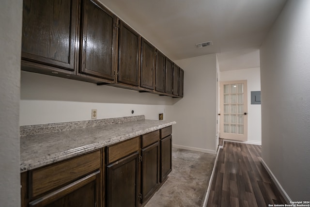 kitchen featuring wood-type flooring and dark brown cabinetry