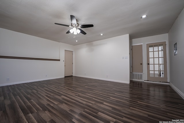 spare room with dark wood-type flooring, a textured ceiling, and ceiling fan