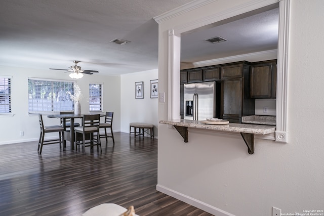 kitchen featuring a kitchen breakfast bar, dark hardwood / wood-style flooring, ceiling fan, stainless steel fridge with ice dispenser, and dark brown cabinetry