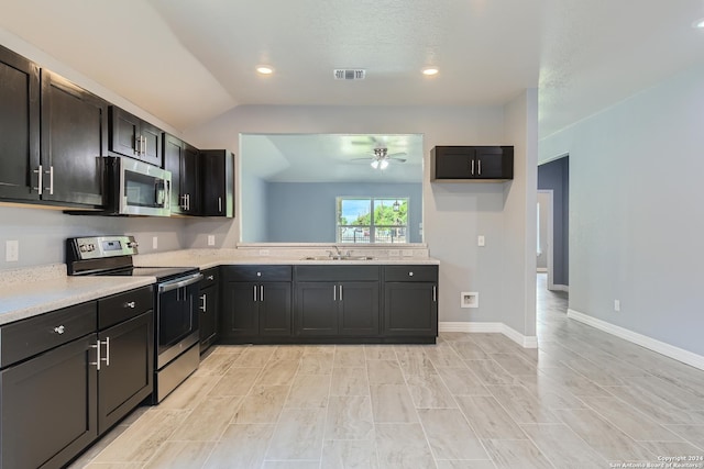 kitchen featuring a sink, baseboards, vaulted ceiling, light countertops, and appliances with stainless steel finishes