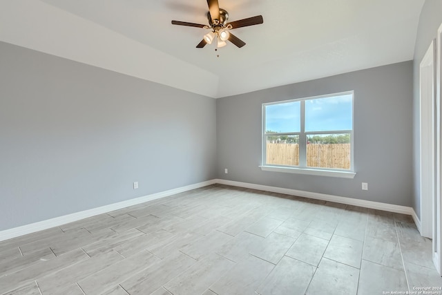 spare room with lofted ceiling, ceiling fan, and baseboards