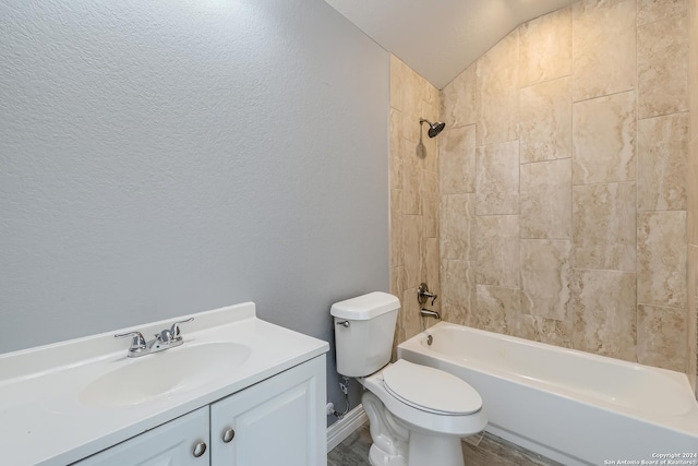 full bath with a textured wall, toilet, tub / shower combination, vaulted ceiling, and vanity