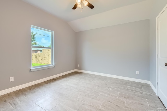 empty room featuring ceiling fan, baseboards, and vaulted ceiling