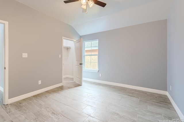 unfurnished room with vaulted ceiling, a ceiling fan, and baseboards