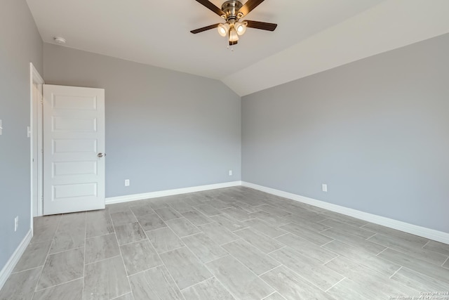 empty room with lofted ceiling, ceiling fan, and baseboards