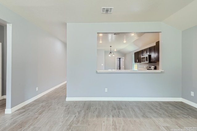 unfurnished living room with visible vents, vaulted ceiling, light wood finished floors, and baseboards