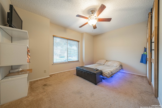 carpeted bedroom with a textured ceiling and ceiling fan