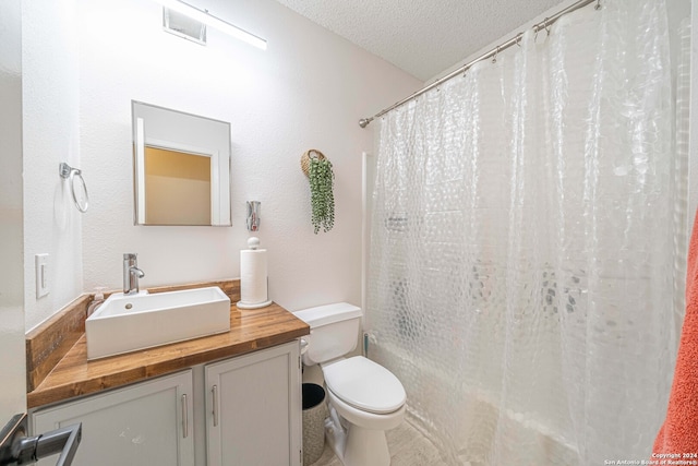 bathroom featuring vanity, toilet, a shower with shower curtain, and a textured ceiling