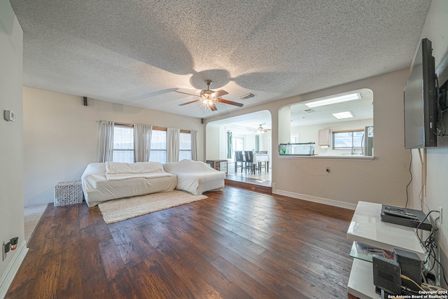 unfurnished bedroom featuring multiple windows, ceiling fan, dark hardwood / wood-style floors, and a textured ceiling