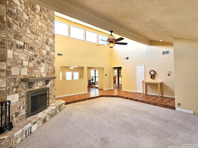 unfurnished living room featuring a wealth of natural light, carpet, a fireplace, and ceiling fan