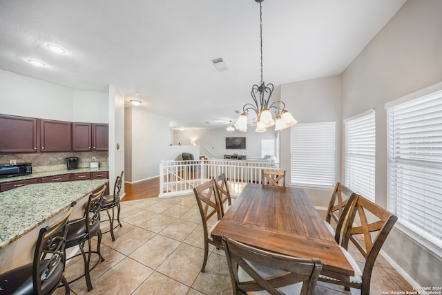 dining area featuring ceiling fan with notable chandelier and light tile patterned floors