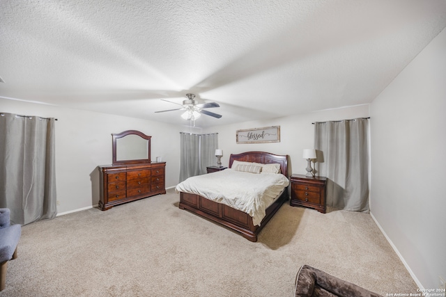 carpeted bedroom with ceiling fan and a textured ceiling