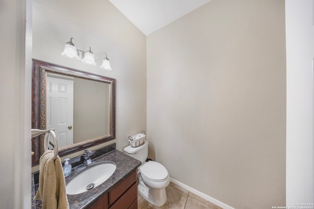 bathroom featuring vaulted ceiling, toilet, vanity, and tile patterned flooring