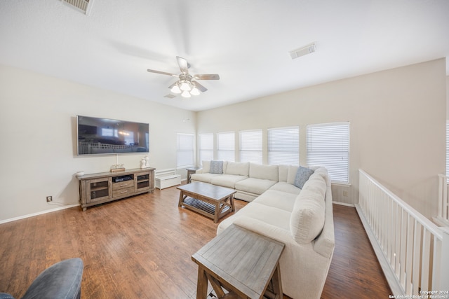 living room featuring a healthy amount of sunlight, ceiling fan, and dark hardwood / wood-style flooring