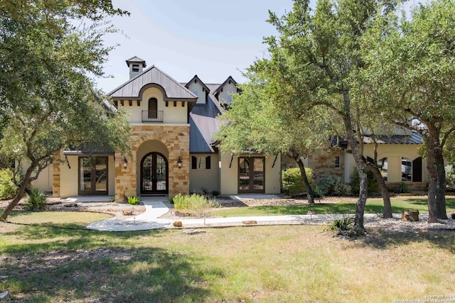 view of front of house with french doors and a front lawn