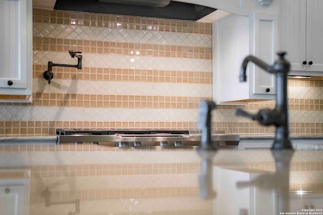 interior details featuring range hood and white cabinets