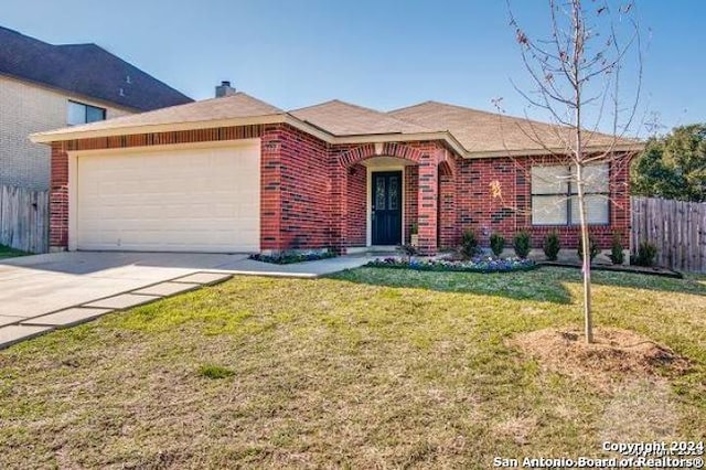 ranch-style home featuring a garage, concrete driveway, fence, a front lawn, and brick siding