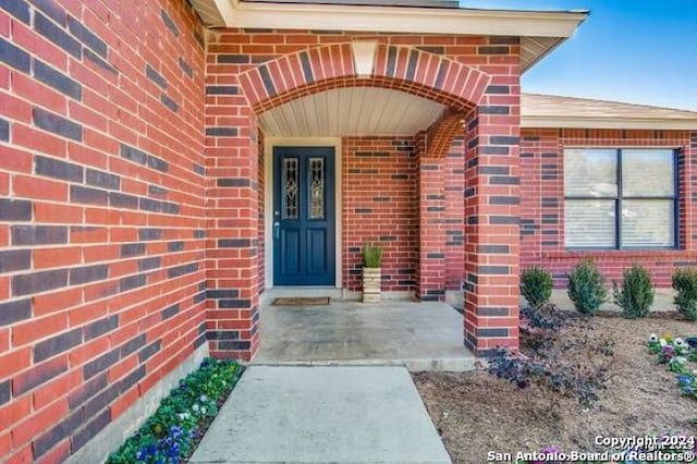 property entrance featuring brick siding