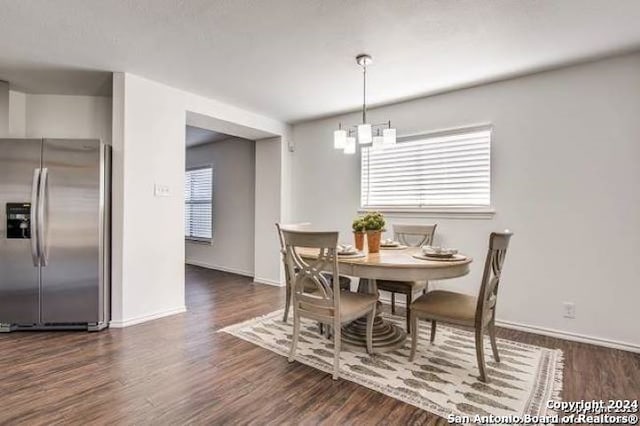 dining area featuring plenty of natural light, dark hardwood / wood-style flooring, and a notable chandelier