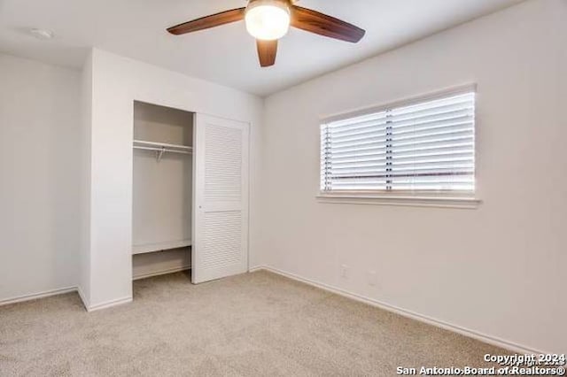 unfurnished bedroom featuring a closet, ceiling fan, and light carpet