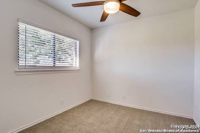 carpeted empty room featuring ceiling fan