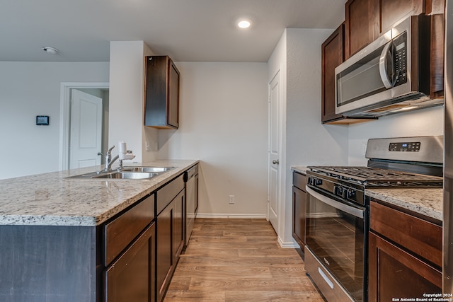 kitchen with light wood-type flooring, sink, appliances with stainless steel finishes, and dark brown cabinets