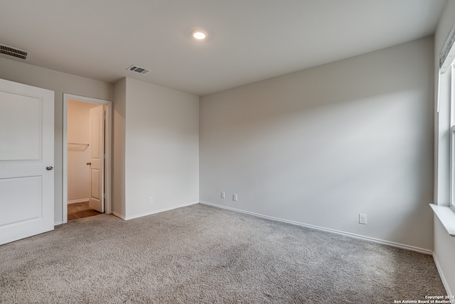 unfurnished bedroom with carpet and a walk in closet