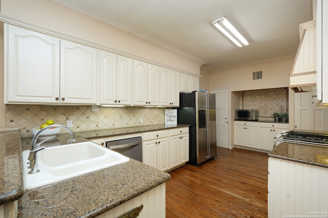 kitchen featuring stone countertops, tasteful backsplash, sink, dark hardwood / wood-style floors, and appliances with stainless steel finishes