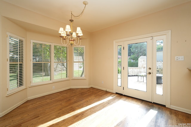 doorway featuring hardwood / wood-style floors, a notable chandelier, and a healthy amount of sunlight