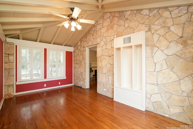 empty room featuring ceiling fan, wood-type flooring, and lofted ceiling with beams