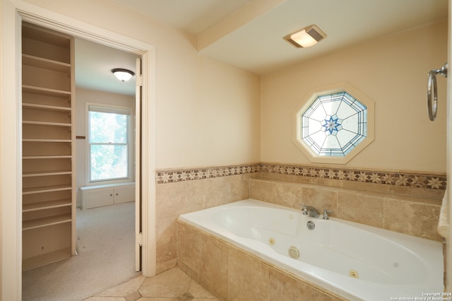 bathroom featuring tile patterned flooring and tiled tub