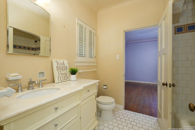 bathroom with toilet, vanity, baseboards, and tile patterned floors