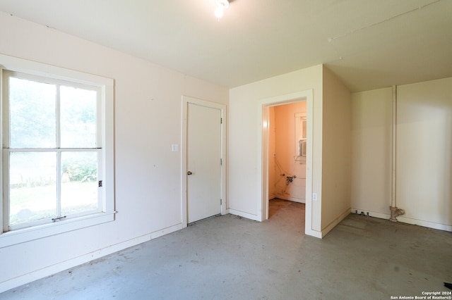 unfurnished bedroom with ensuite bath and multiple windows