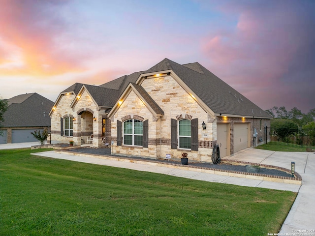 french country inspired facade with a garage and a lawn