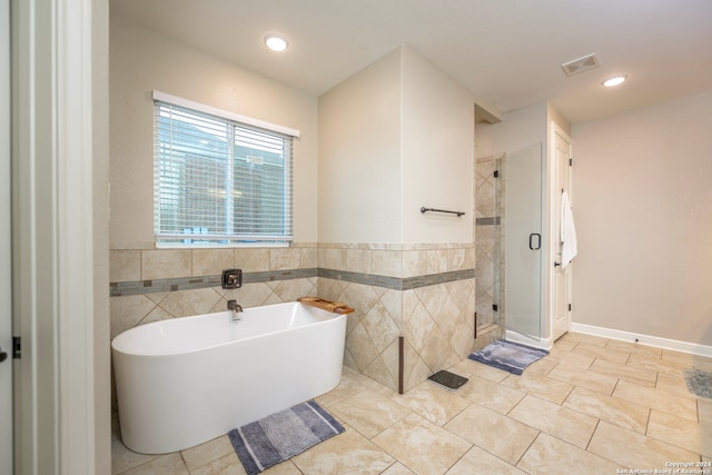 bathroom featuring tile walls, tile patterned flooring, and independent shower and bath