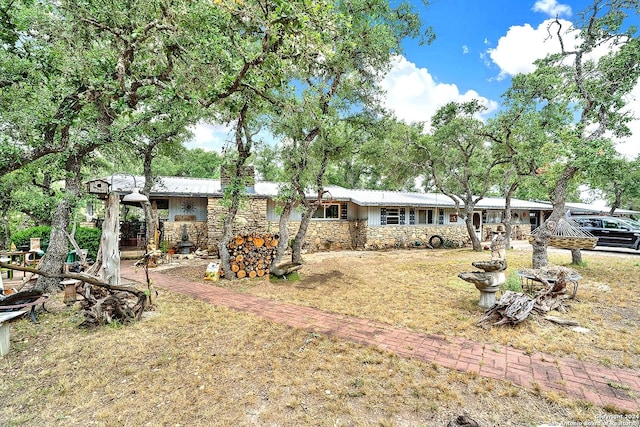 back of property featuring stone siding