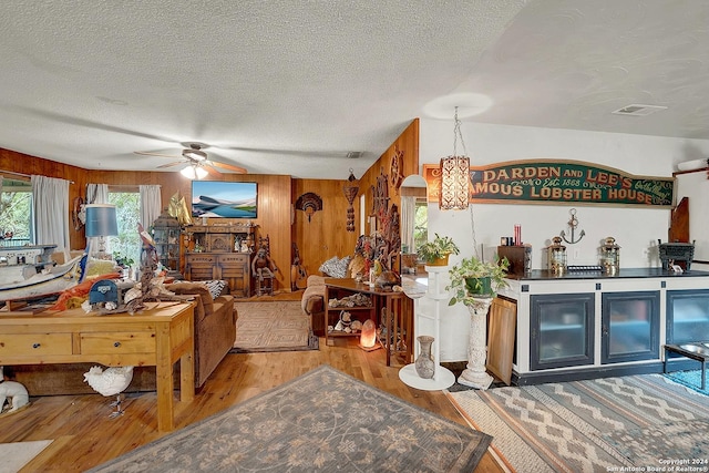 interior space with arched walkways, visible vents, wood walls, a textured ceiling, and wood finished floors