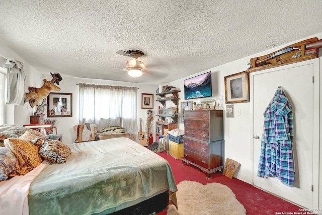 bedroom featuring a textured ceiling, carpet floors, and a ceiling fan