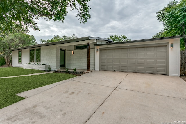 single story home featuring a front yard and a garage