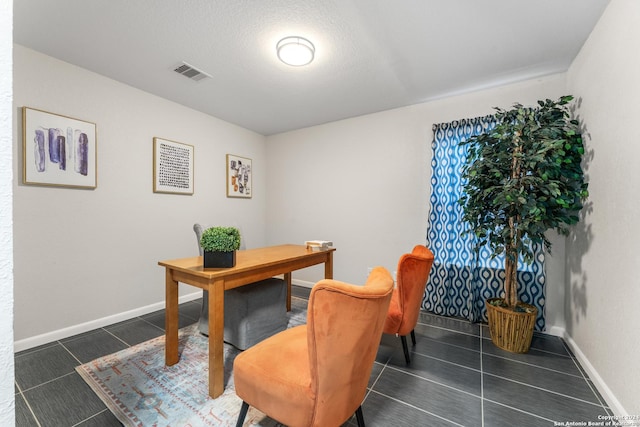 office area with visible vents, baseboards, and dark tile patterned flooring