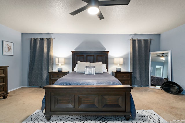 bedroom with ceiling fan, light carpet, and a textured ceiling