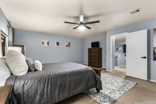 carpeted bedroom with visible vents, baseboards, and a ceiling fan